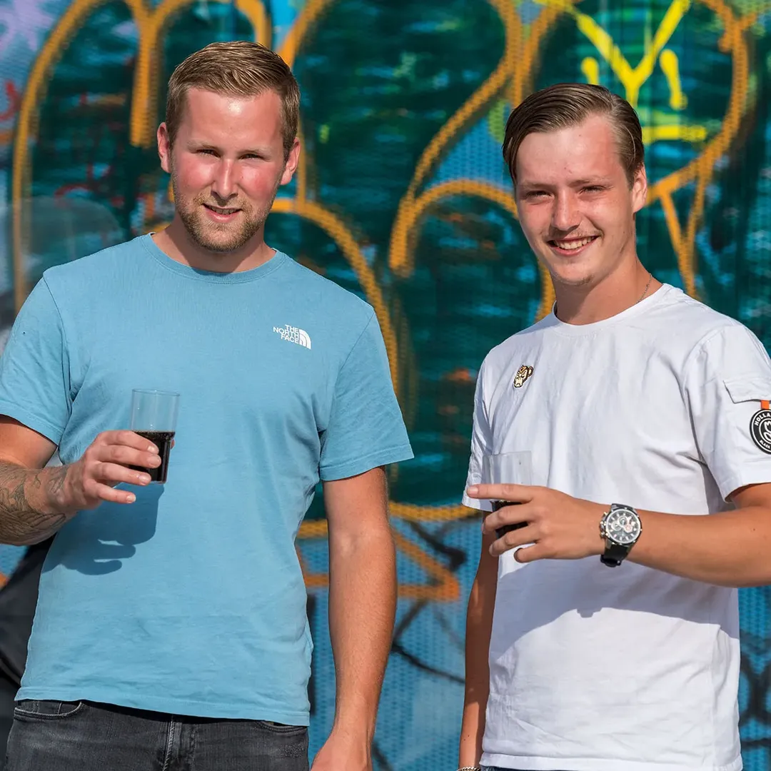 Twee collega’s met een drankje op een feest van Klomp